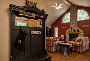 Una sala de estar acogedora con chimenea, sofás de cuadros y un banco de madera.
