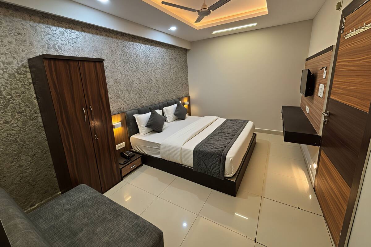 A modern bedroom with a bed, bedside tables, a wardrobe, a television, and a ceiling fan.