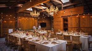 A large banquet hall with high ceilings, wooden walls, and chandeliers. Tables are set with white tablecloths, candles, and floral centerpieces. - Waterfront Sonoma Russian Rvr Lux Vineyard Ranch on Creek, Pool+HotTub+Bocce+Pet (Sebastopol)