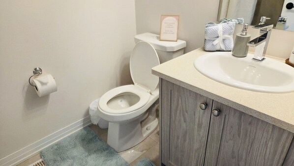 Une salle de bain équipée de toilettes, d’un lavabo et d’un porte-serviettes avec des serviettes.