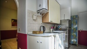 A compact kitchen with white cabinets, a stainless steel refrigerator, and a tiled backsplash. - RIPA HOME LOFT IN TRASTEVERE (Roma)
