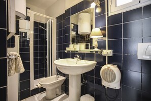 A bathroom with a white sink, a bidet, a mirror, and a towel rack. - RIPA HOME LOFT IN TRASTEVERE (Roma)
