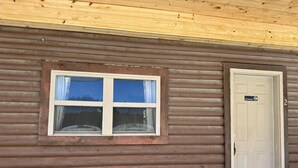 Una cabaña de madera con ventana y puerta.
