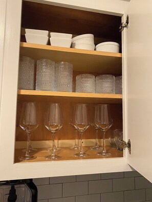 Ett skåp med hyllor där glas och porslin förvaras.