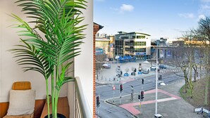 A modern building with a glass facade, a visible sign for 'MOTORSPORT', and a traffic intersection with multiple lanes and traffic lights. - Spacious NG1 City Centre Apartment Near Motorpoint Arena, sleeps 6 (Nottingham)