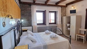 Un dormitorio con cama, escritorio, armario y ventana.