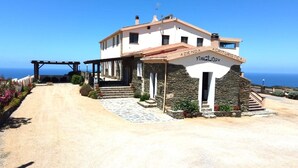 Un edificio de dos pisos con fachada de piedra y un letrero que dice "Azienda Agrituristica".