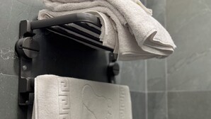 Ein Badezimmer mit Handtuchhalter, gefalteten Handtüchern und einem Handtuch mit dekorativer Musterung.
