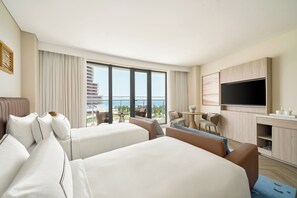 A hotel room with two beds, a desk, a TV, and a balcony with a view. - Melia Serenity Cam Ranh Beach Resort (Cam Lam)