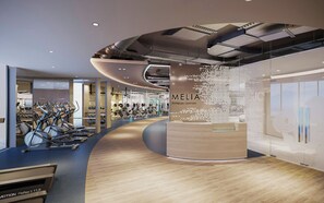 A modern fitness center with cardio equipment, weight machines, and a central information kiosk. - Melia Serenity Cam Ranh Beach Resort (Cam Lam)