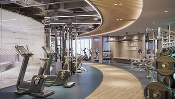 Un gimnasio moderno con máquinas de cardio, pesas libres y una frase motivacional en la pared.