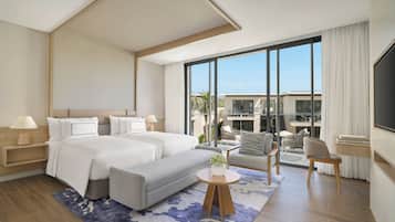 Une chambre d’hôtel moderne dotée d’un grand lit, d’un coin salon et offrant une vue sur la ville.