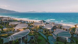 A resort with modern architecture, beachfront location, and a view of the ocean. - Melia Serenity Cam Ranh Beach Resort (Cam Lam)
