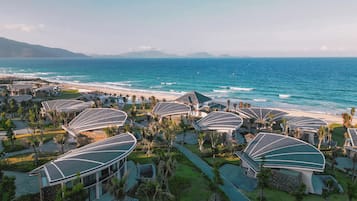 A resort with modern architecture, beachfront location, and a view of the ocean.