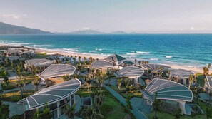 A resort with modern architecture, beachfront location, and a view of the ocean. - Melia Serenity Cam Ranh Beach Resort (Cam Lam)