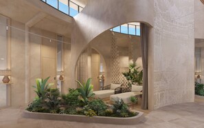 A spacious lobby with a high ceiling, arched doorways, and a central seating area surrounded by lush greenery. - Melia Serenity Cam Ranh Beach Resort (Cam Lam)