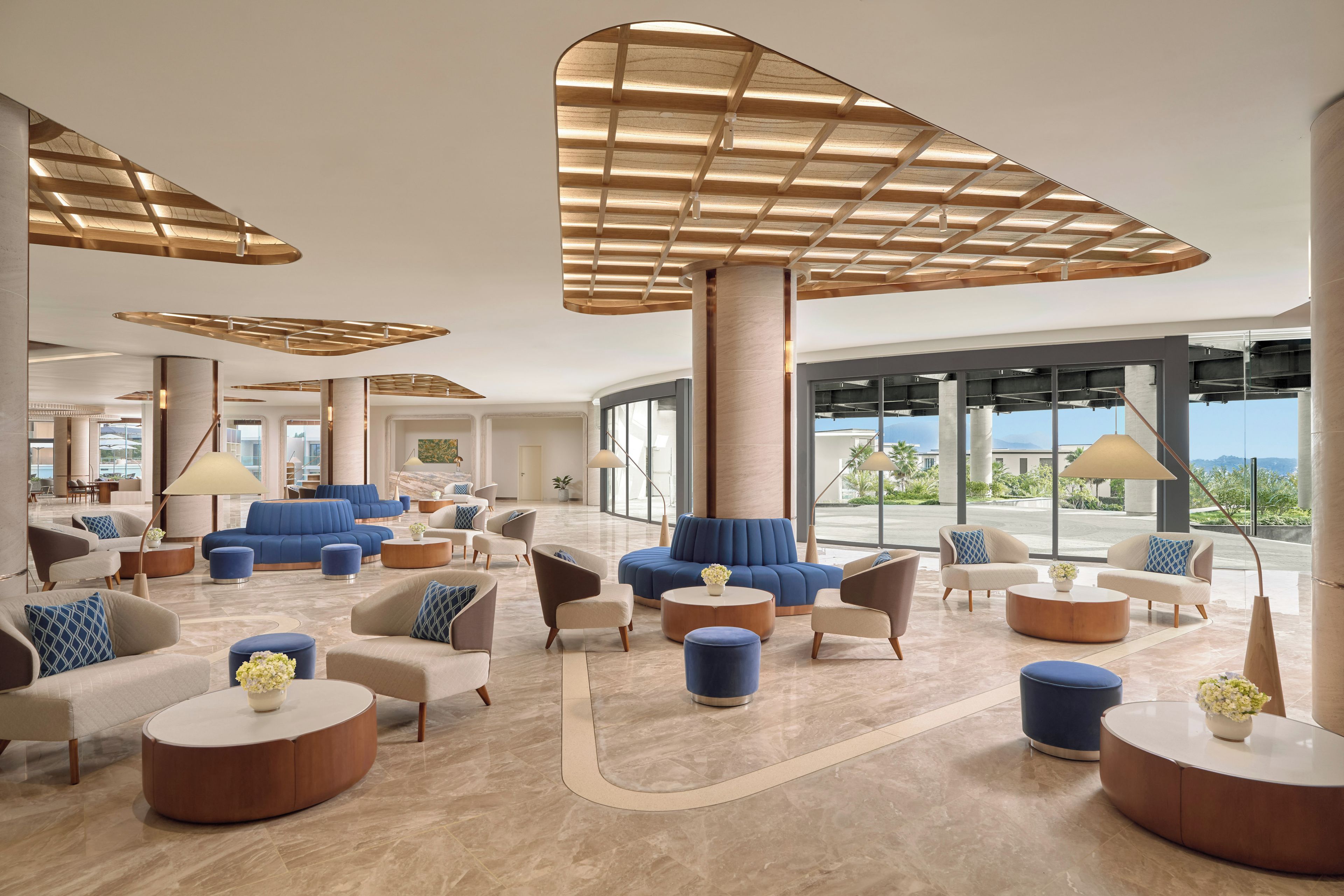 A spacious lobby with modern furniture, large windows, and a view of the outdoors.