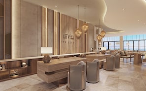 A modern hotel lobby with a long reception desk, seating area, and large windows offering a view. - Melia Serenity Cam Ranh Beach Resort (Cam Lam)