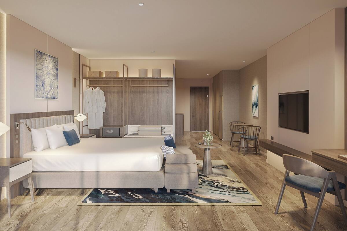 Ein modernes Hotelzimmer mit einem großen Bett, Nachttischen, einem Schreibtisch und einem Fernseher.