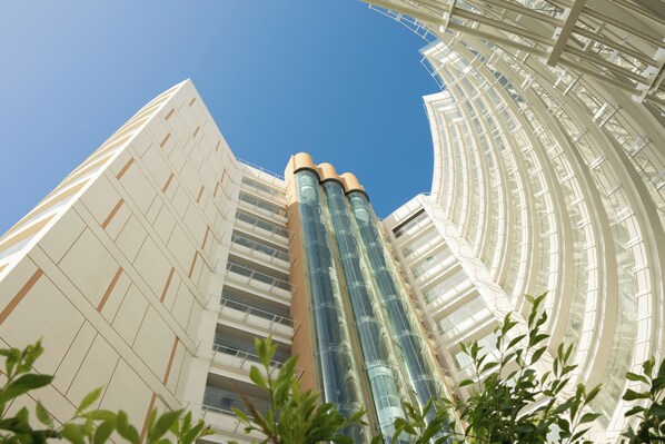 Un edificio moderno con fachada de vidrio curvo y varios balcones.
