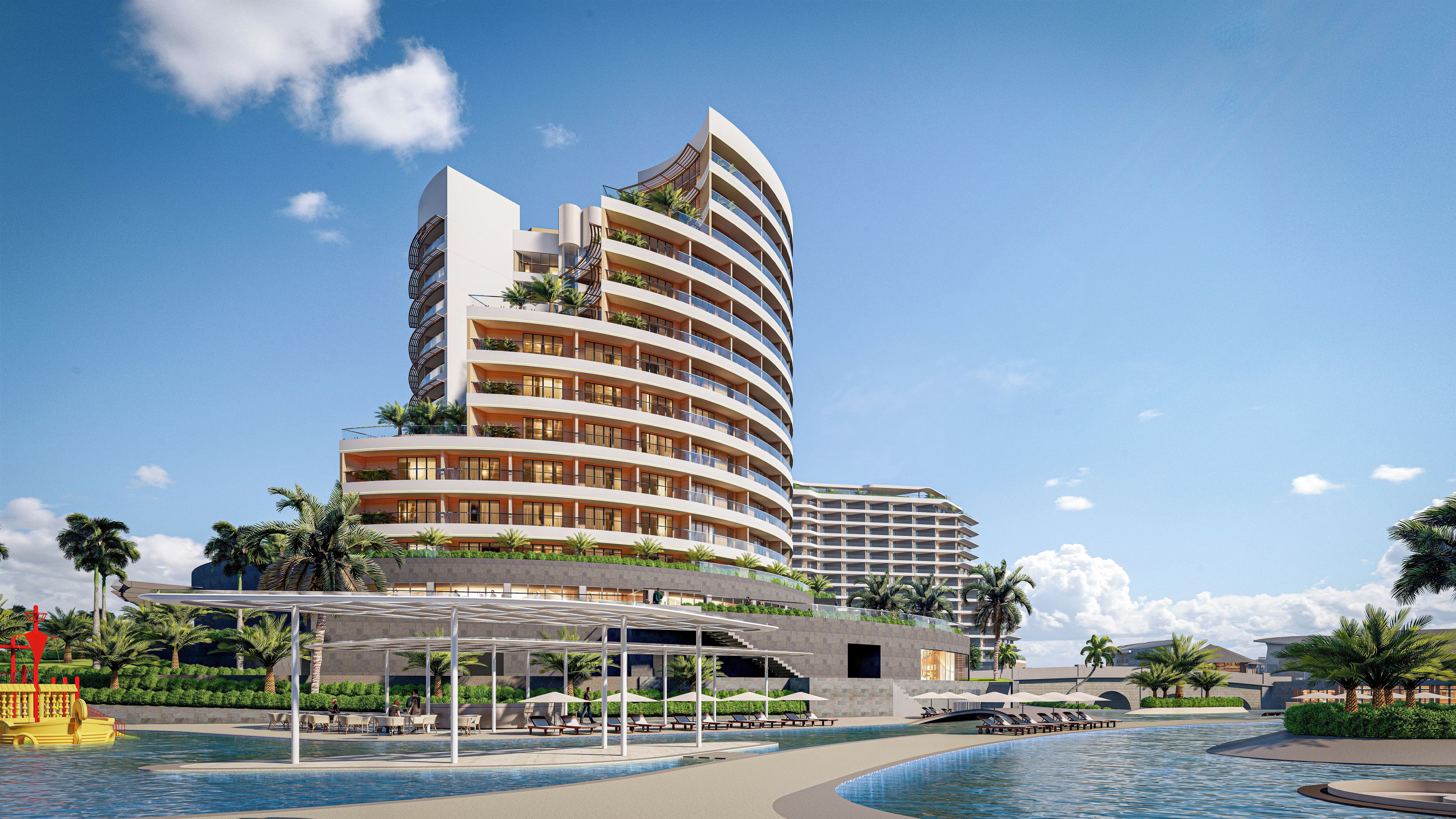 A modern hotel with a curved facade, multiple balconies, and a pool area with sun loungers and umbrellas.