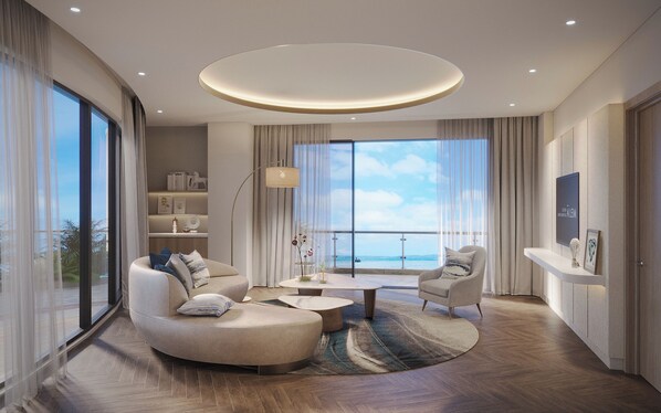 Un salon moderne avec un canapé aux lignes courbes, une table basse et une vue sur la mer.
