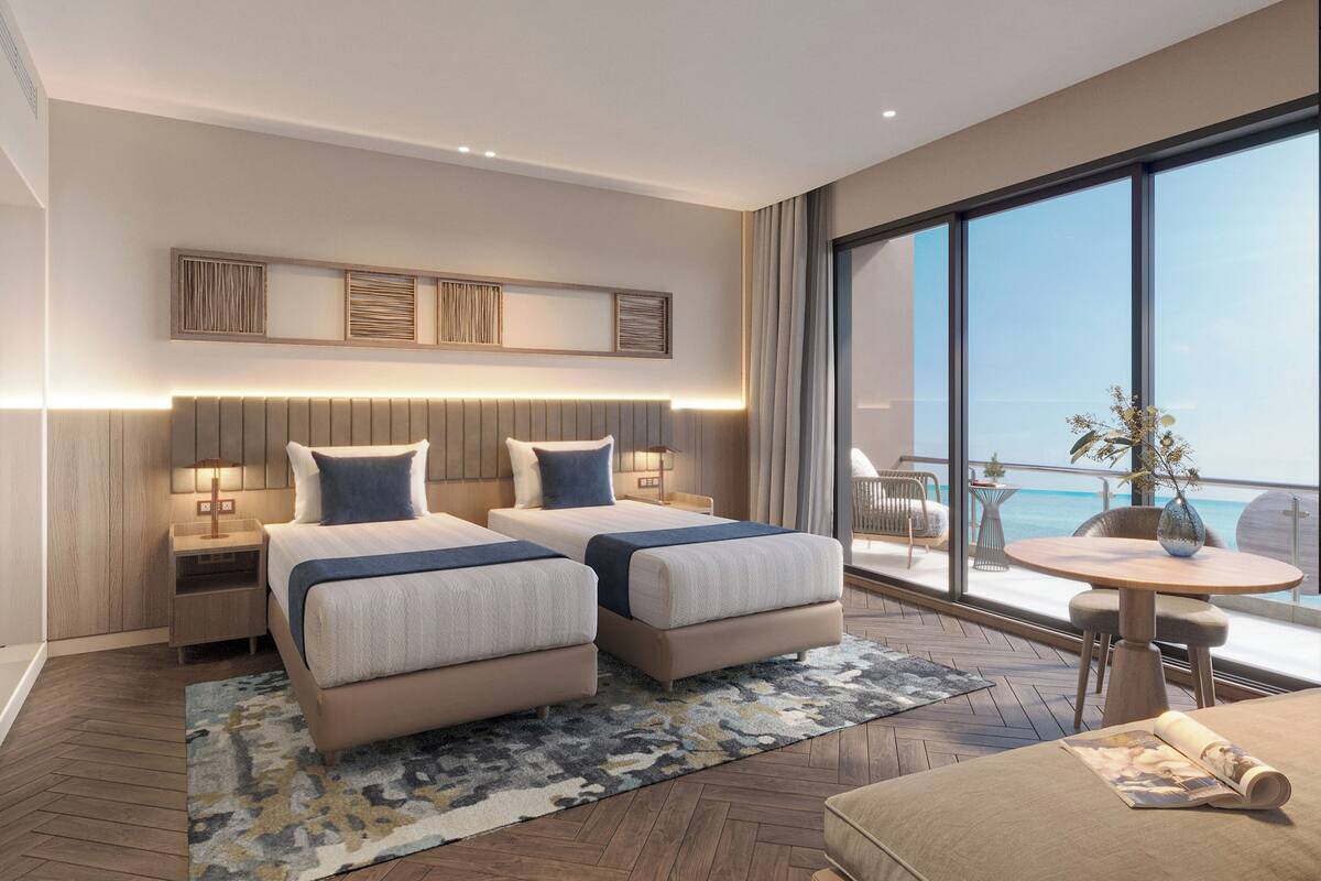 Ein modernes Hotelzimmer mit zwei Betten, einem Balkon und Blick sowie einem kleinen Tisch mit einer Vase.