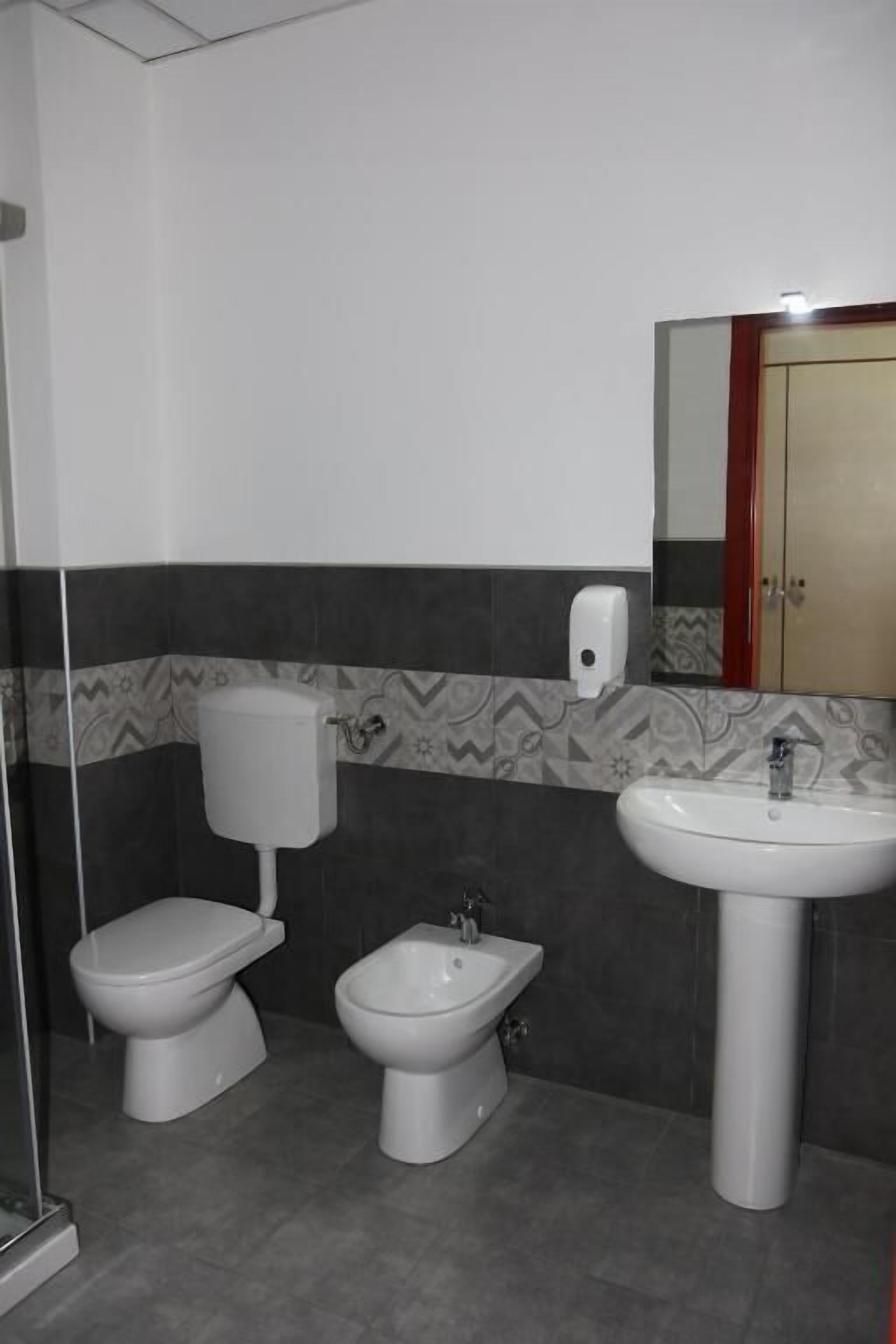 A bathroom with a toilet, bidet, and sink.