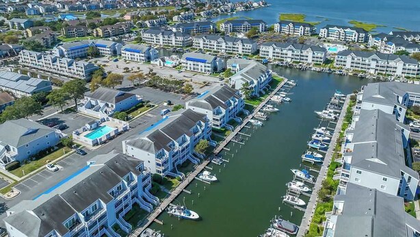 Un puerto deportivo con barcos amarrados, rodeado de edificios de varios pisos con balcones, probablemente parte de un hotel o complejo residencial.