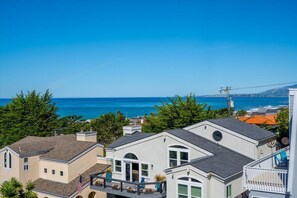 A coastal residential area with houses, a clear blue sky, and the ocean in the background. - Awesome Views: Near Beach, Single Floor, Dogs OK (Cambria)