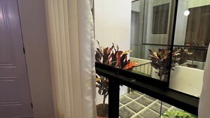 Un intérieur moderne avec une balustrade en verre, des plantes en pot et une vue sur un sol carrelé.
