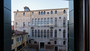 Un edificio histórico con varios pisos, ventanas amplias y un patio interior.