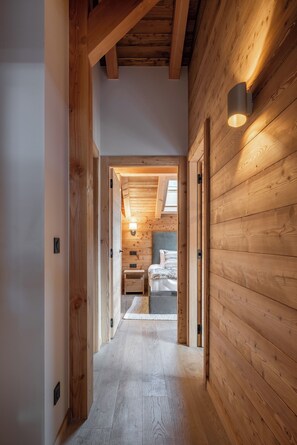 A wooden hallway leading to a bedroom with a skylight and a bedside table. - Chalet Arole - Alpine retreat with jacuzzi Morzine (Morzine)