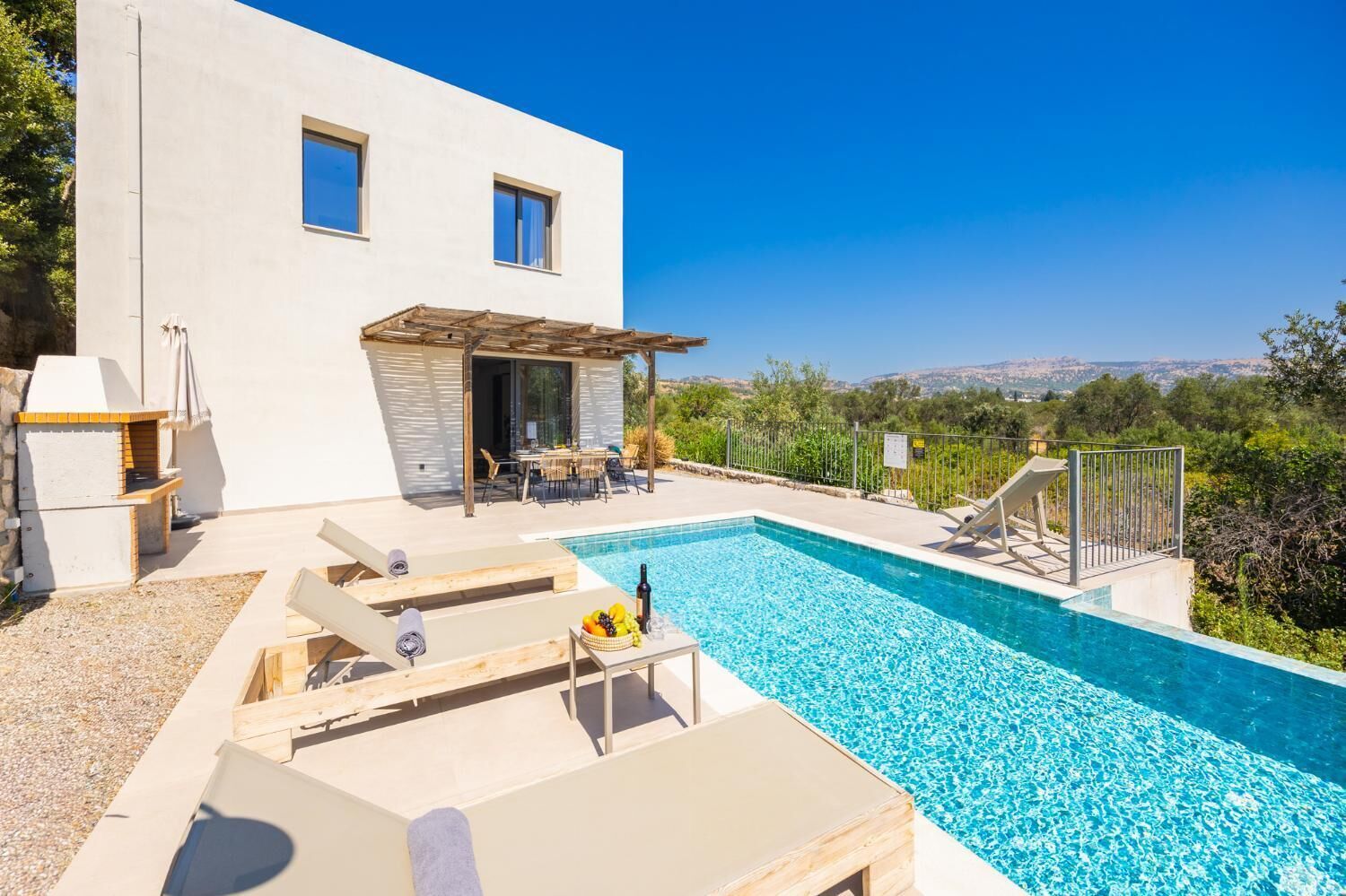 Une maison moderne dotée d’une piscine, de mobilier d’extérieur et d’un espace patio.