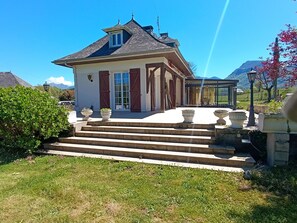 A house with a sloped roof, a front porch with steps, and a view of mountains in the background. - Villa Béarnaise close to the mountains, the Basque country and Spain (Arette)