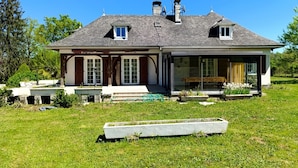 Ein Haus mit einer großen Veranda, einer Garage und einem überdachten Außenbereich.