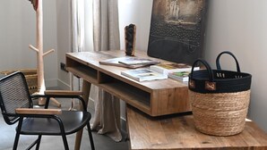 A wooden desk with a basket and books, a chair, a lamp, and a painting on the wall. - Château de Scalibert (Teyssode)