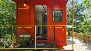 Un edificio rojo con puerta, un pequeño porche y un letrero que dice 'Fresh Flowers'.