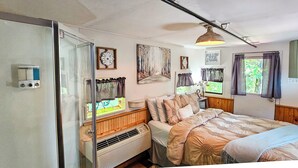 Un dormitorio acogedor con cama, un calentador, una ventana con cortinas y un reloj de pared.