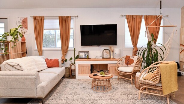 Ein gemütliches Wohnzimmer mit einer Couch, einem Couchtisch, einem Fernseher und einem Schreibtisch.