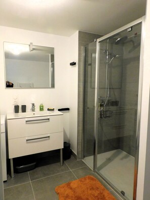 Een douche, handdoeken, zeep, toiletpapier