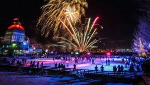 An outdoor ice skating rink with a crowd of people and a building with a red dome in the background. - NDG Treasure in Montreal! Value & Travel Adventure (Montréal)