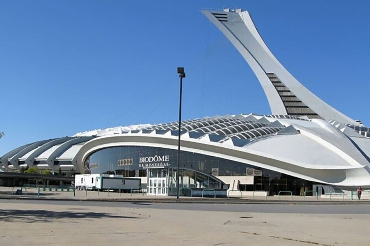 En modern, böjd byggnad med skylten ”BIODOME DE MONTREAL”, vilket visar att det är en utställningslokal med fokus på natur.