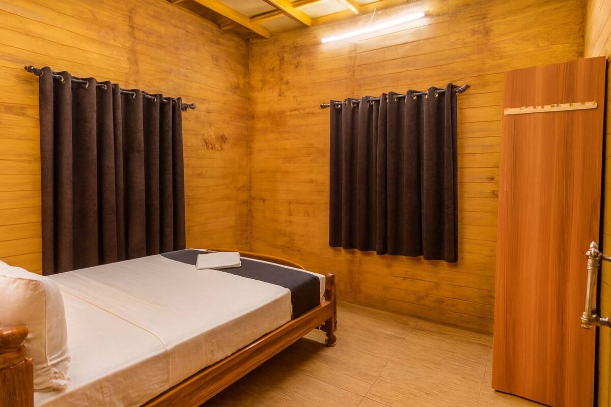 Une pièce en bois avec un lit, des rideaux et une armoire.