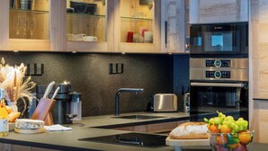 Eine moderne Küche mit Holzausstattung, einer Mikrowelle, einem Toaster und einem Spülbecken.