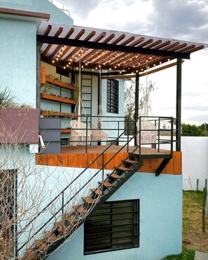 A modern house with a covered outdoor area, a staircase, and a pergola with string lights. - Casa Terraza Oaxaca (Oaxaca de Juárez)