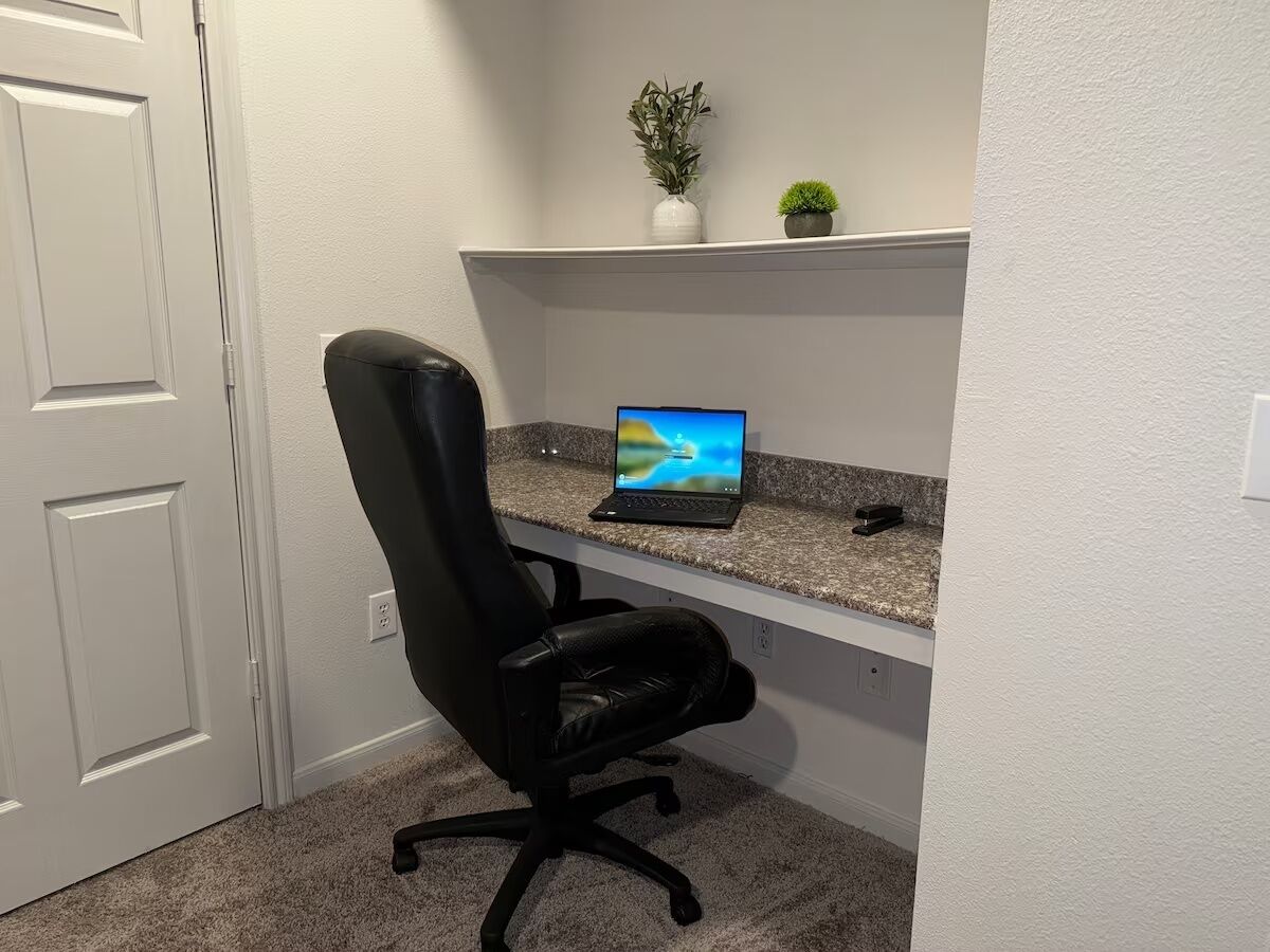A home office setup with a desk, chair, and computer.