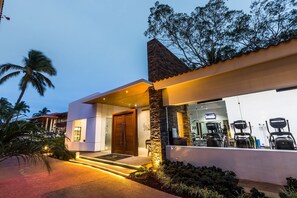 A modern building with a stone facade, a large glass window, and a well-lit entrance. - El Cid Marina Beach Hotel - All Inclusive (Mazatlán)