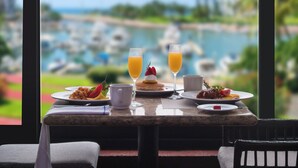 A dining table with breakfast items and drinks, overlooking a marina with boats. - El Cid Marina Beach Hotel - All Inclusive (Mazatlán)