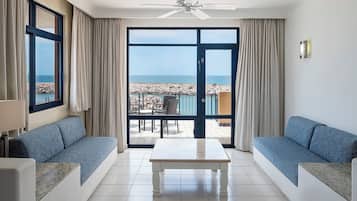 Una habitación con un amplio ventanal corredero que da a un balcón con vista al mar.